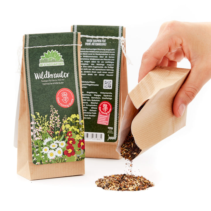 Hand öffnet eine Packung mit Wildkräuter-Saatgut.
